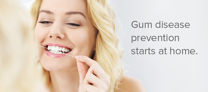 A woman flosses to prevent gum disease