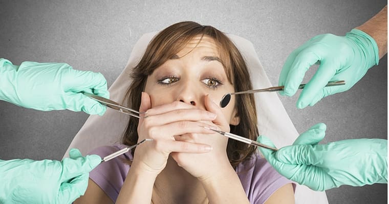 A woman with dental anxiety covering her mouth