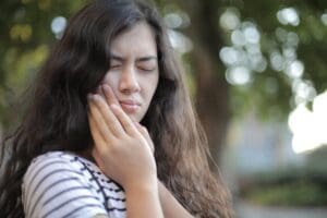 Girl with toothache caused by tooth sensitivity